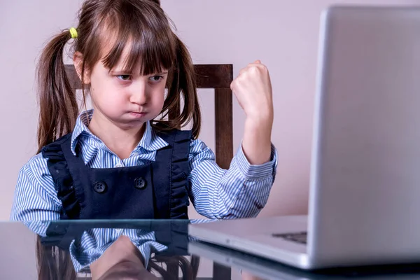 Çocuklar için çevrimiçi eğitim. Kızgın kız bilgisayarla uzaktan öğreniyor.
