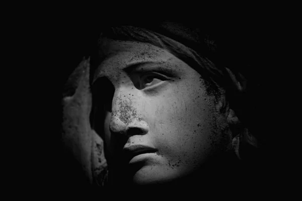 黒を背景に深い影を持つ聖母マリアの古代の像の断片 — ストック写真