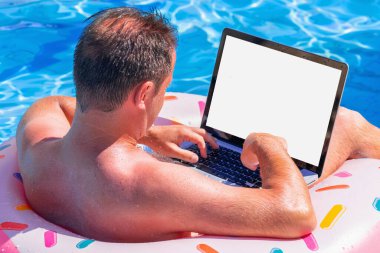 Yaz tatilinde havuzda şişirilebilir bir çemberde yüzen ve bilgisayarla uzaktan çalışan işadamlarının arka görüntüsü. Yatay resim.