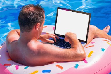 Yaz tatilinde iş adamının havuzda şişirilebilir bir çemberde yüzdüğü ve bilgisayarla uzaktan kumandalı bir şekilde çalıştığı görüntüler.. 
