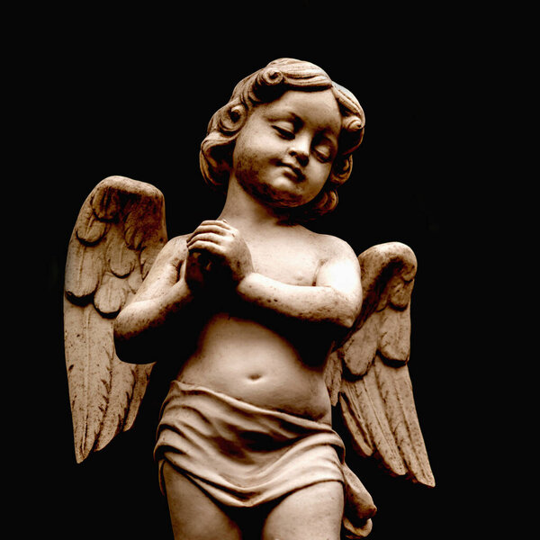 Angel of death. Fragment of an ancient statue against black background.