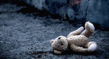 Kayıp çocukluk, yalnızlık, acı ve depresyon. Kavramsal görüntü: Açık havada yatan kirli oyuncak ayı. Yatay görüntü. Boşluğu kopyala.