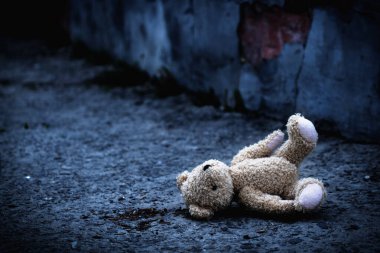 Kayıp çocukluk, yalnızlık, acı ve depresyon. Kavramsal resim: Açık havada duran kirli oyuncak ayı. Yatay görüntü. Tasarım veya metin için boşluk kopyala.