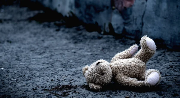 Kayıp çocukluk, yalnızlık, acı ve depresyon. Kavramsal görüntü: Açık havada yatan kirli oyuncak ayı. Yatay görüntü. Boşluğu kopyala.