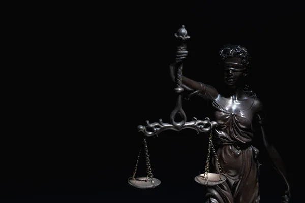 Lady Justice with scales of truth against black background. Conceptual image of justice, law and legal system. Copy space.