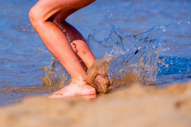 Deniz suyuna atlayan tatlı bir genç kız. Yaz tatili, seyahat, mutlu çocukluk ve dinlenme konsepti.