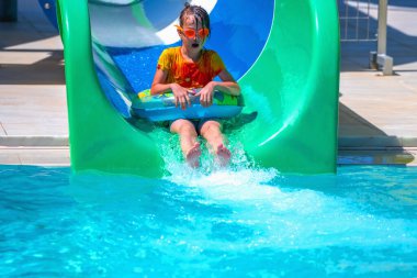 Yaz boyunca su kaydırağına inen genç kızın portresi. Yaz tatili ve mutlu çocukluk konsepti.