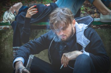 Votka içen bir çift adam ve kadın. Sarhoş genç insanlar. Alkolizm, evsizlik, sosyal bağımlılık sorunu, yıkıcı ve antisosyal davranış kavramı. 