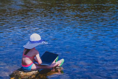 Küçük kız görüntülü konuşma yapıyor. Bilgisayarla uzaktan öğreniyor. Yaz tatili ve tatil konsepti, uzaktan öğrenme. Boşluğu kopyala.