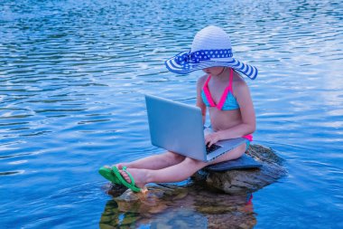 Küçük kız görüntülü konuşma yapıyor. Bilgisayarla uzaktan öğreniyor. Yaz tatili ve tatil konsepti, tabletle online çalışma, uzaktan öğrenme. Boşluğu kopyala.