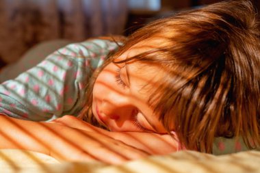 Kavramsal görüntü: mutluluk, dikkatsizlik ve mutlak güvenlik duygusu. Genç, güzel bir kız sabah güneşinde uyuyor.. 