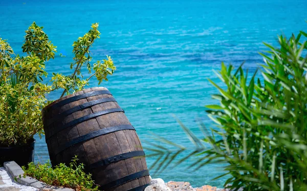 Wooden barrel of pirated gold and money against nautical landscape. Copy space.