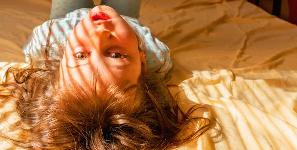 概念的なイメージ 不注意で絶対的な安全性の感覚 幼い娘が目を覚ますとベッドに横たわっています スペースのコピー — ストック写真
