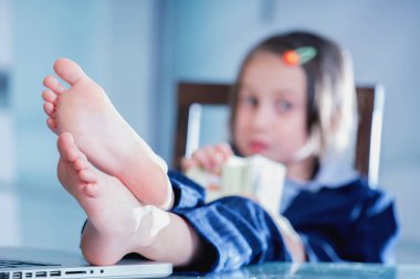 Young business girl with bare foots on the table in the office dreams of summer vacation. 