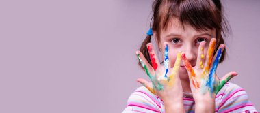 Renkli elleri mutluluk ve neşe sembolü olan mutlu küçük şirin kız çocuğunun portresi. Metin veya tasarım için boşluk kopyala.
