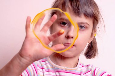 Beautiful young girl painting painting sun on glass with fingers. Art, creativity, education and leisure concept.