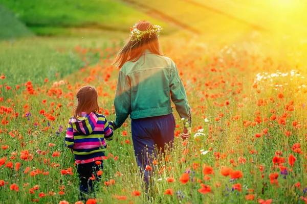 Two Young Girls Sisters Walking Poppy Field Sun Rays 로열티 프리 스톡 사진