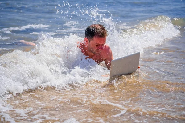 Education and work always and everywhere as the best way to be successful. Conceptual image of male entrepreneur working with laptop in the water of sea