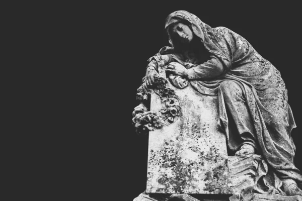 Ancient stone statue of sad and desperate woman on tomb. Copy space. Black and white horizontal image.