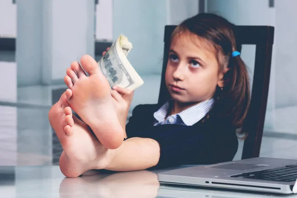 Humorous portrait of happy cute young business girl counts money profit. Selective focus on bare feet. Horizontal image.