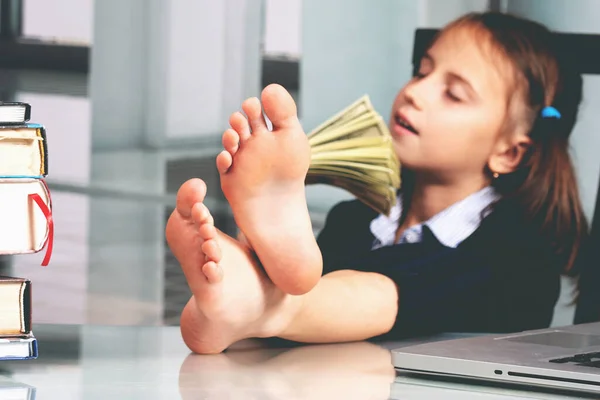 Portrait of very happy cute young business girl counts money profit. Selective focus on bare feet