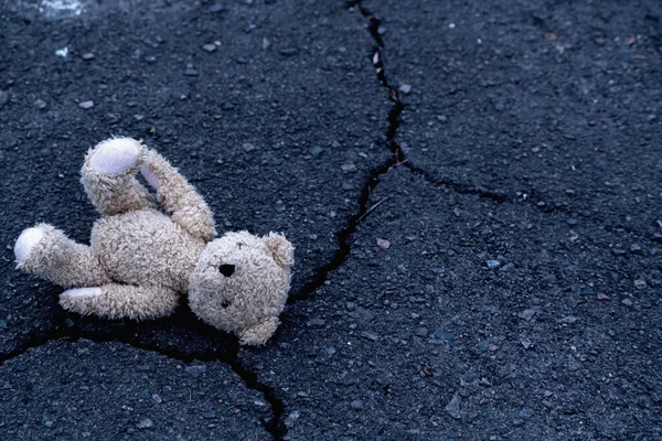 Kavramsal görüntü: Oyuncak ayı oyuncağı çocukların yalnızlığının, acısının, kırık çocukluğun ve kayıp geleceğinin sembolü olarak sokakta unutuldu. Metin ya da tasarım için kopyalama alanı.