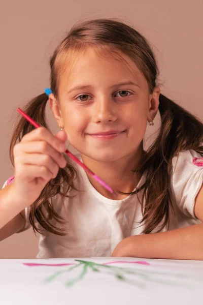 Art and painting lessons. Young girl learning painting with water colors. Young female artist drawing at home, using colorful brushes. Vertical image.