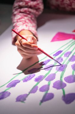 Çizim yapmayı öğrenen genç bir kızın yüz resmi yok. Eldeki seçici odaklanma. 