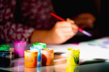 Çizim yapmayı öğrenen genç bir kız. Boyalı tüplere odaklan.. 