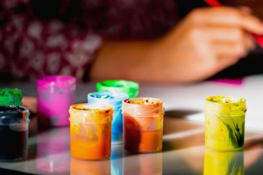 Sanat, aktif yaşam tarzı ve yaratıcılık kavramı. Çizim yapmayı öğrenen genç bir kızın yüz resmi yok. Boyalı tüplere odaklan..