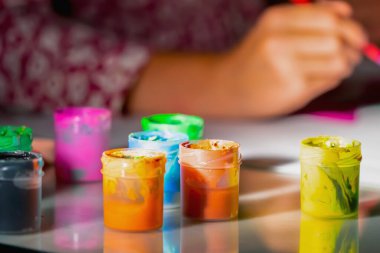 Sanat, aktif yaşam tarzı ve yaratıcılık kavramı. Çizim yapmayı öğrenen genç bir kızın yüz resmi yok. Boyalı tüplere özen göster. Yatay resim.