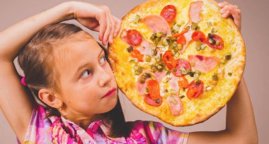 Fast food ve pizzacı kavramı. Neşeli kız pizza dilimleriyle eğleniyor. Yatay resim.