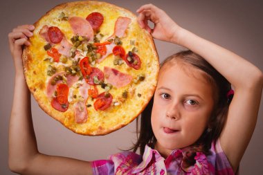 Genç, güzel, çekici kız lezzetli pizzanın tadını çıkarıyor.,