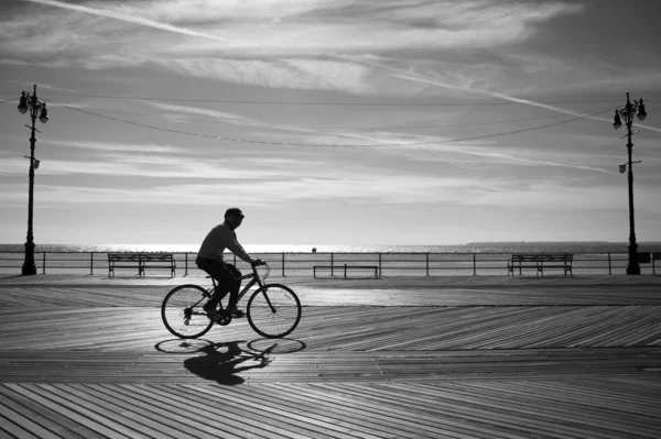 Верховая езда на велосипеде на рассвете на пляже — стоковое фото