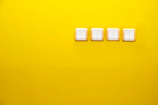 Electrical white rocker light switches on orange wall. — Stock Photo, Image