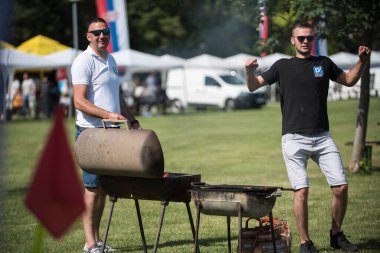 5 Haziran 2022 'de. - TEMERIN, SERBIA: Sırbistan 'ın Temerin kentinde 5 Haziran 2022' de Sırbistan 'da düzenlenen Pasuljijada Bean Festivali 2022 Gıda ve Müzik Festivali Sahneleri. İnsanlar güzel bir yaz gününün tadını çıkarırken, geleneksel yemek ve içecekler DJ ve müzik B