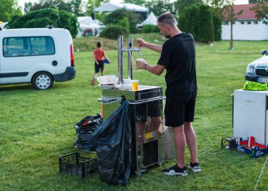 5 Haziran 2022 'de. - TEMERIN, SERBIA: Sırbistan 'ın Temerin kentinde 5 Haziran 2022' de Sırbistan 'da düzenlenen Pasuljijada Bean Festivali 2022 Gıda ve Müzik Festivali Sahneleri. İnsanlar güzel bir yaz gününün tadını çıkarırken, geleneksel yemek ve içecekler DJ ve müzik B