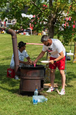 5 Haziran 2022 'de. - TEMERIN, SERBIA: Sırbistan 'ın Temerin kentinde 5 Haziran 2022' de Sırbistan 'da düzenlenen Pasuljijada Bean Festivali 2022 Gıda ve Müzik Festivali Sahneleri. İnsanlar güzel bir yaz gününün tadını çıkarırken, geleneksel yemek ve içecekler DJ ve müzik B