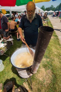 5 Haziran 2022 'de. - TEMERIN, SERBIA: Sırbistan 'ın Temerin kentinde 5 Haziran 2022' de Sırbistan 'da düzenlenen Pasuljijada Bean Festivali 2022 Gıda ve Müzik Festivali Sahneleri. İnsanlar güzel bir yaz gününün tadını çıkarırken, geleneksel yemek ve içecekler DJ ve müzik B