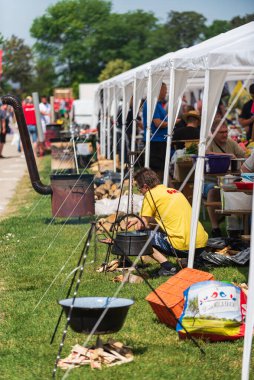 5 Haziran 2022 'de. - TEMERIN, SERBIA: Sırbistan 'ın Temerin kentinde 5 Haziran 2022' de Sırbistan 'da düzenlenen Pasuljijada Bean Festivali 2022 Gıda ve Müzik Festivali Sahneleri. İnsanlar güzel bir yaz gününün tadını çıkarırken, geleneksel yemek ve içecekler DJ ve müzik B