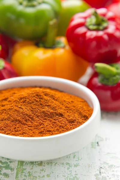 Paprika macinata in una ciotola di porcellana bianca e pepe fresco — Foto Stock