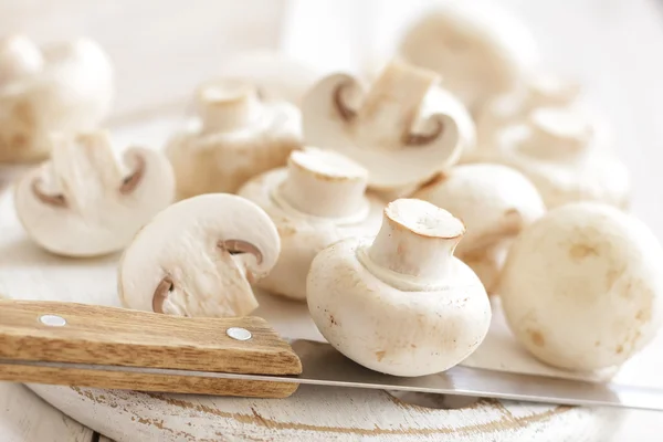 Champignons and a knife on a table — Stock Photo, Image