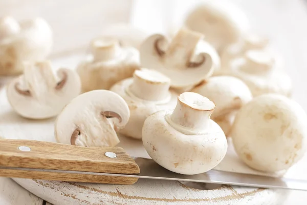 Champignons e un coltello su un tavolo — Foto Stock