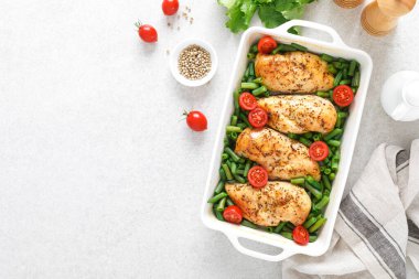 Tavuk eti, göğüs pişmiş ve beyaz arka planda domatesli yeşil fasulye. Keto diyeti. Sağlıklı yiyecekler. Üst görünüm.