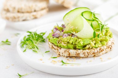 Taze salatalık, soğan, susam tohumu, mikroçerez ve avokado ile vejetaryen açık sandviç. Sağlıklı vejetaryen yemekleri, diyeti.