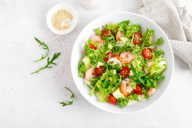 Karides, domates ve avokado yaz sebze salatası taze marul, roket ve susamlı. Sağlıklı beslenme. Keto, ketojenik diyet. Üst görünüm.