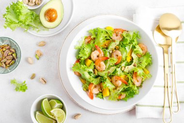 Avokado, mango, marul ve şam fıstıklı ızgara karides salatası. Limonlu. Sağlıklı yiyecekler. Ketogenik diyet. Üst görünüm.