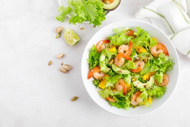 Avokado, mango, marul ve şam fıstıklı ızgara karides salatası. Limonlu. Sağlıklı yiyecekler. Ketogenik diyet. Üst görünüm.