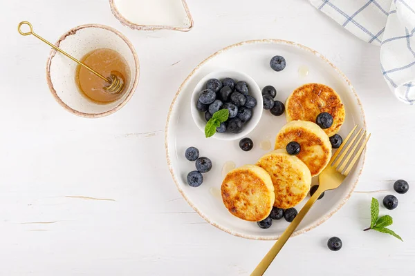 用蜂蜜和新鲜蓝莓做的奶酪或凝乳松饼 健康饮食 顶部视图 — 图库照片