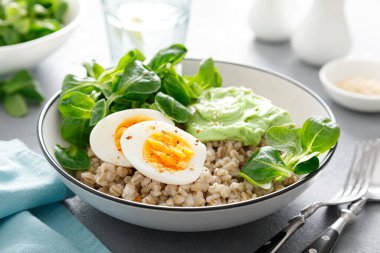 Yumuşak yumurta ve mısır salatalı inci arpa kasesi.